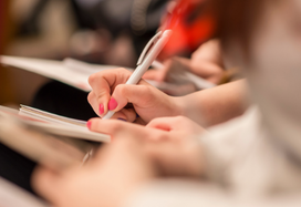 row of people taking notes at a conference