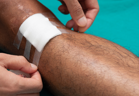 man applying plaster to pressure ulcer on leg