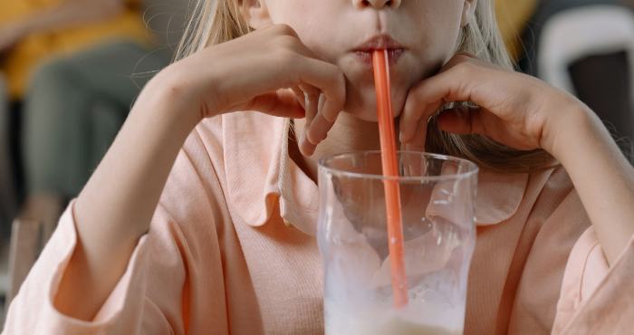 young girl drinking ONS through a straw