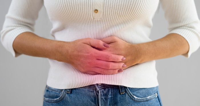 lady with bowel cancer holding her tummy
