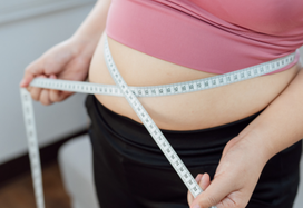 lady measuring waistline with measuring tape