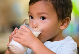 child drinking oral nutritional supplement from a glass