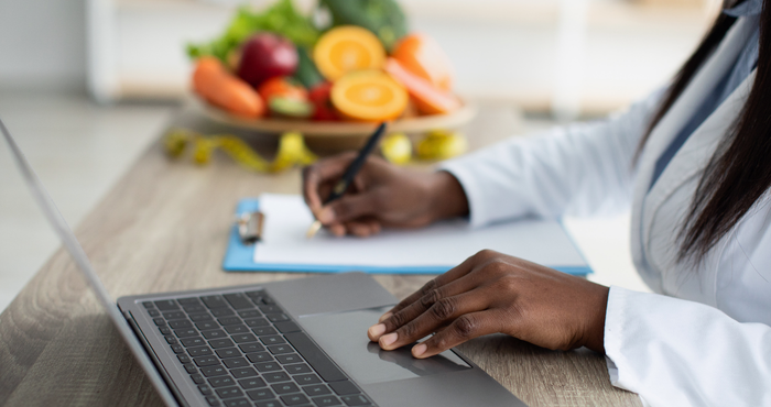 dietitian at work with bowl of fruit in background