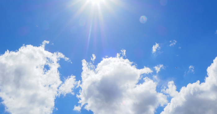 the beaming sun shining through clouds