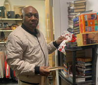 Photo of Wisdom Dhinha helping at Dougie Mac's charity shop