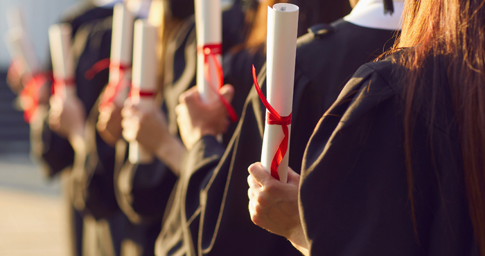 graduates holding their certificates