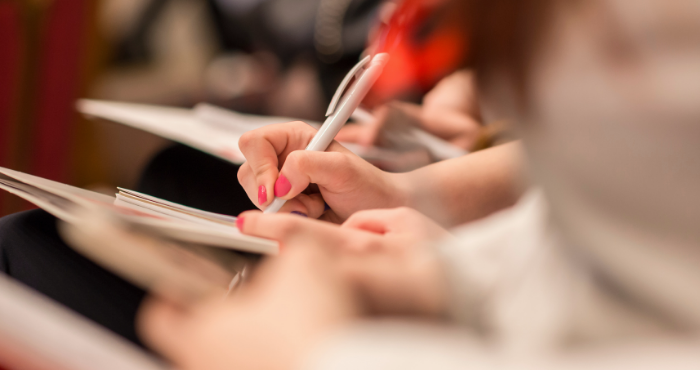 row of people taking notes at a conference