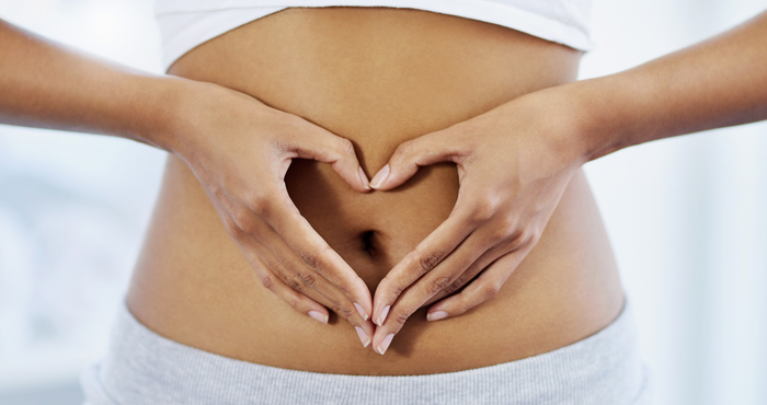 lady making heart shape with hands over her stomach