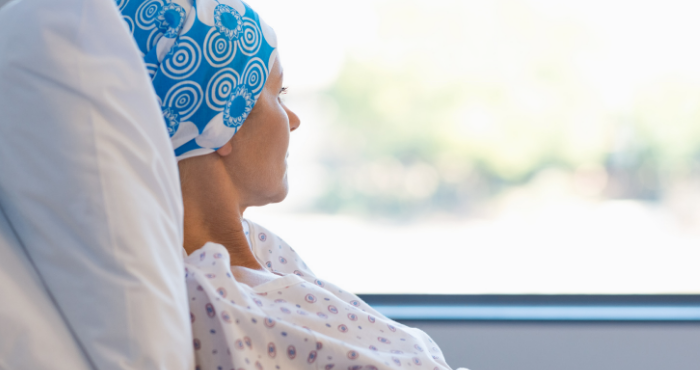 Lady with cancer sitting up in bed