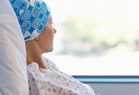 Lady with cancer sitting up in bed
