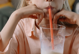 young girl drinking ONS through a straw