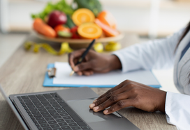 dietitian at work with bowl of fruit in background