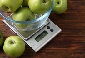 apples being weighed on kitchen scales